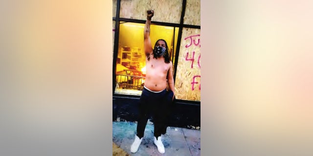 Photo of Montez Terriel Lee Jr. in front of the
burning pawn shop.