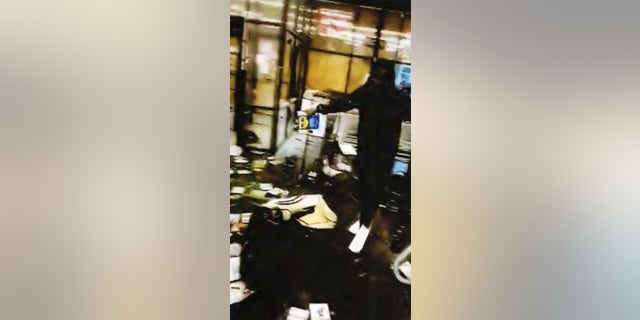 A still of Montez Terriel Lee Jr. pouring liquid over the pawn shop.