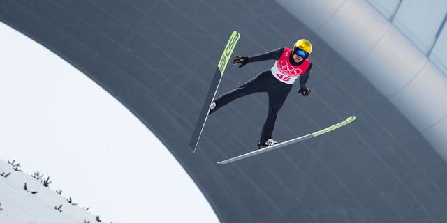 Vinzenz Geiger, d'Allemagne, s'élance dans les airs lors d'une manche d'essai dans la partie saut à ski de l'épreuve individuelle de tremplin normal de Gundersen aux Jeux olympiques d'hiver de 2022, le mercredi 9 février 2022, à Zhangjiakou, en Chine. 