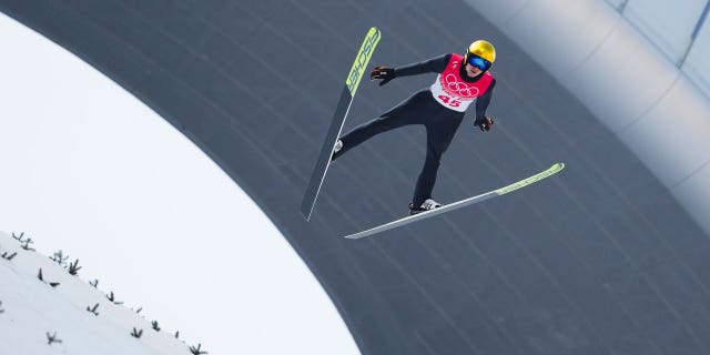 Vinzenz Geiger, d'Allemagne, s'élance dans les airs lors d'une manche d'essai dans la partie saut à ski de l'épreuve individuelle de tremplin normal de Gundersen aux Jeux olympiques d'hiver de 2022, le mercredi 9 février 2022, à Zhangjiakou, en Chine. 