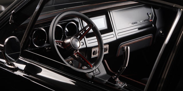 The interior features a 3D-printed dashboard and knife-style shifter.