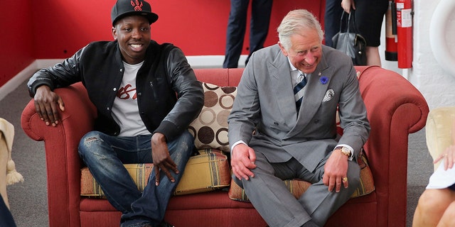 FILE - Britain's Prince Charles, right,sits on a sofa with Jamal Edwards during a live session at the launch of the Prince's Trust Summer Sessions at the Princes's Trust in Historic Chatham Dockyard in Chatham, England, July 7, 2013.