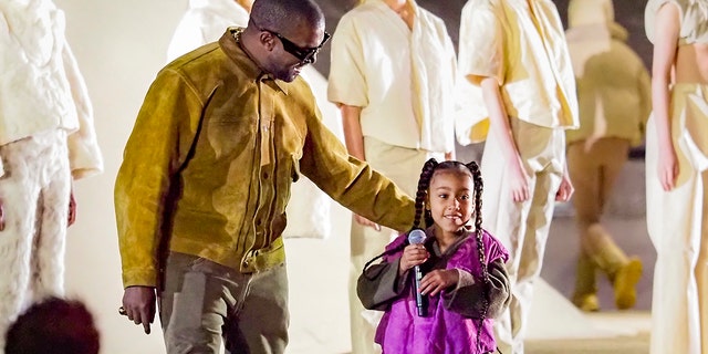  Kanye West with daughter North West at the "Yeezy Season 8" show in March 2020 in Paris, France. North is the oldest of the former couple's four children.