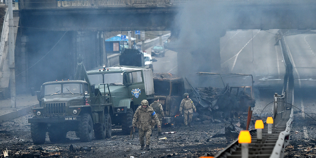 Ukrainian service members are seen at the site of a fighting with Russian raiding group in the Ukrainian capital of Kyiv in the morning of February 26, 2022.