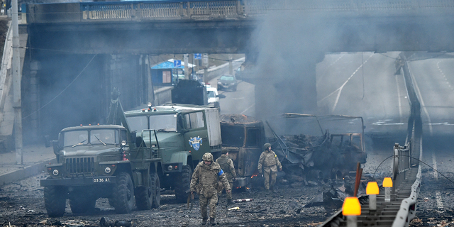 Ukrainian service members are seen at the site of a fighting with Russian raiding group in the Ukrainian capital of Kyiv in the morning of February 26, 2022,