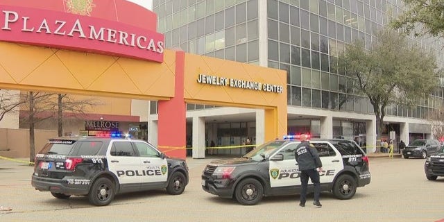 Houston police cruiser gather in front of the PlazAmericas Mall where a law enforcement officer and suspect were reportedly shot Wednesday. Local reports said the officer and suspect both died.