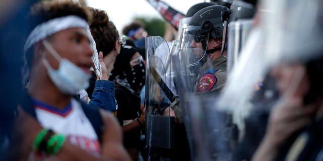 Demonstrators face members of the Austin Police Department as they gather in downtown Austin, Texas, on June 4, 2020, to protest the death of George Floyd