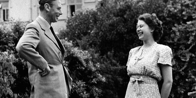 Britain's Queen Elizabeth II, then Princess Elizabeth, right, with her father King George VI, in the grounds of the Royal Lodge, Windsor, England, Aug. 20, 1946. 