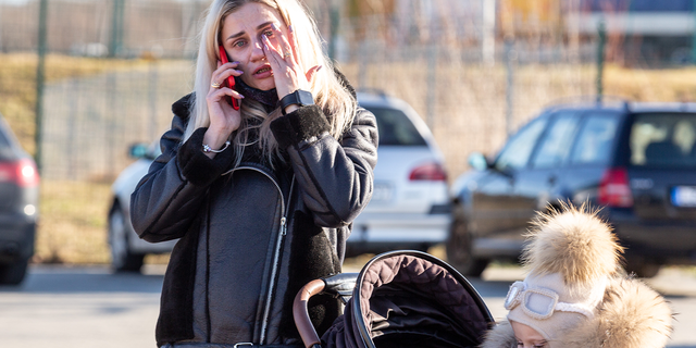 An Ukrainian mother cries after crossing to Poland as first migrants from Ukraine enter Poland after Russia bombarded Ukrainian territory.