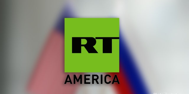 American and Russian flag pair on desk over defocused background. Horizontal composition with copy space and selective focus.