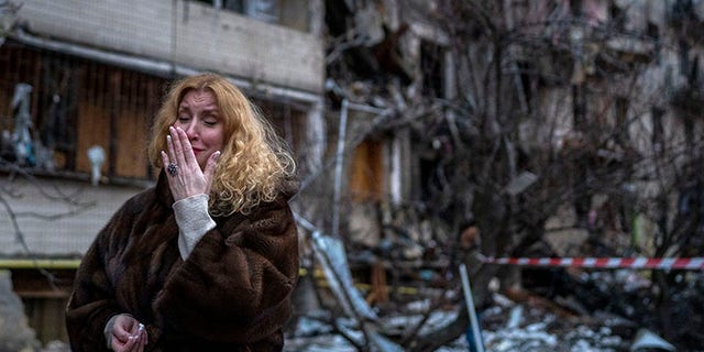 Natali Sevriukova reacts next to her house following a rocket attack on the city of Kiev, Ukraine, Friday, February 25, 2022. 