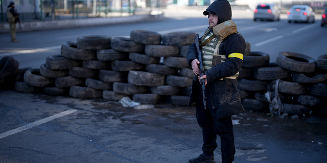 A participant in the civil defense stands at a checkpoint in Kyiv, Ukraine, on Saturday, February 26, 2022.