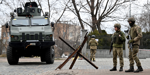 Des militaires des forces militaires ukrainiennes bloquent une route dans le soi-disant quartier gouvernemental de Kiev le 24 février 2022, alors que les forces terrestres russes ont envahi l'Ukraine depuis plusieurs directions aujourd'hui, encerclant le pays quelques heures après que le président russe a annoncé sa décision de lancer un assaut.