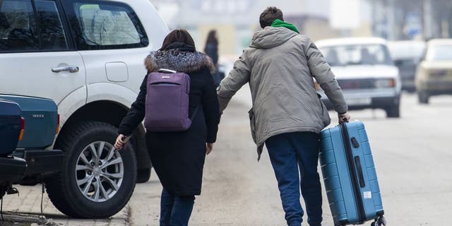 Люди несут свои сумки после начала российской военной операции 24 февраля 2022 года в Краматорске, Украина.