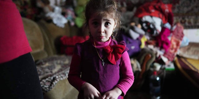 On Feb. 20, 2022, this young girl — age 4 — is photographed inside a house where she lives with her family after shelling by separatist forces in Novognativka, in eastern Ukraine.