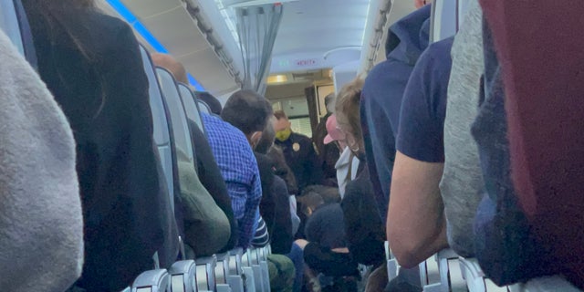 A 50-year-old man had to be subdued after he allegedly tried to open the plane's exit door. 