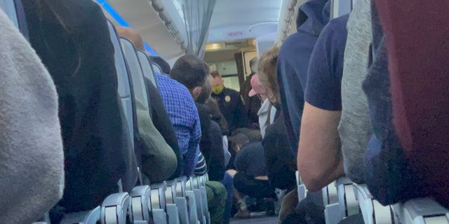 A 50-year-old man had to be subdued after he allegedly tried to open the plane's exit door. 