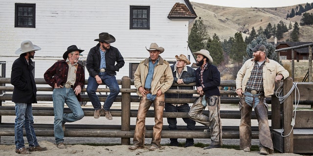 John Dutton (center - Kevin Costner), owner of the Dutton Ranch is surrounded by his ranch team (pictured l to r) Walker (Ryan Bingham), Lloyd (Forrie Smith), Rip Wheeler (Cole Hauser), Jimmy (Jefferson White), Colby (Denim Richards) and Fred (Luke Peckinpah.)