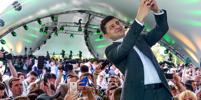Ukrainian President Volodymyr Zelenskyy takes a selfie at the first congress of his party called Servant of the People in the city Botanical Garden, Kiev, Ukraine, Sunday, June 9, 2019.