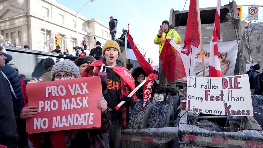 A protester in support of masks and vaccines makes their way through a demonstration in support of a trucker convoy in Ottawa protesting COVID-19 restrictions