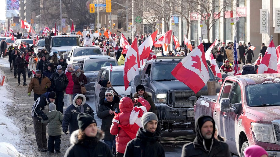 Trucks and supporters travel down Bloor Street during a demonstration in support of a trucker convoy in Ottawa protesting COVID-19 restrictions, in Toronto, Saturday, Feb. 5, 2022. 