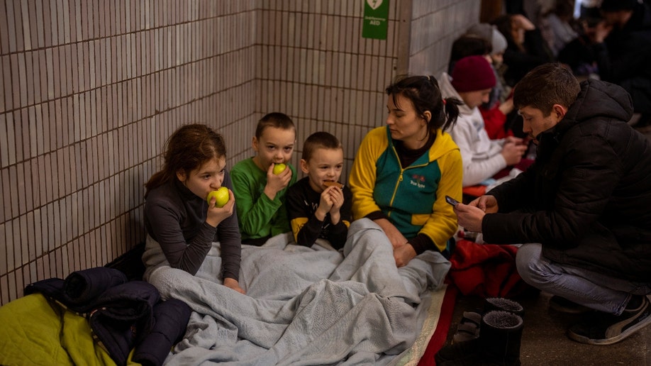 عائلة تجلس في مترو أنفاق كييف، تستخدمه كملجئ من القنابل في كييف