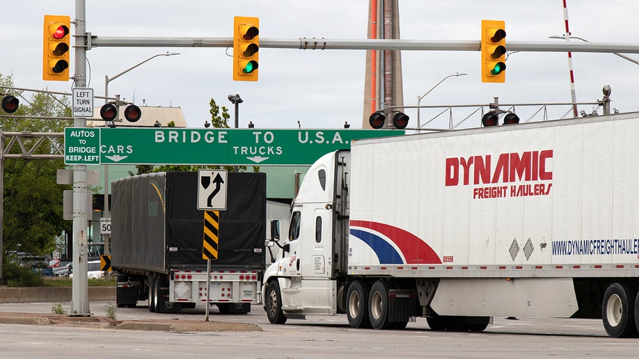 Transport trucks pass under a "Bridge To USA" at the entrance to the Ambassador Bridge, US-Canada border crossing in Windsor, Ontario.