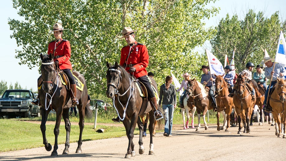 Bruce, Canada - July 26, 2015: Royal Canadian Mounted Police leading a parade in a small rural community. The people behund the RCMP are local horsemen.