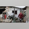 A woman is seen in front of a damaged building in Donetsk's Petrovskaya, which is under control of pro-Russian separatists, as Russian attacks continue in Ukraine on February 28, 2022.