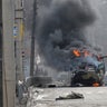 A Russian Armoured personnel carrier (APC) burns next to an unidentified soldier's body during a fight with the Ukrainian armed forces in Kharkiv.