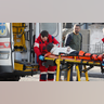 Medical specialists transport a woman, who was wounded in the shelling of an apartment building, to an ambulance, as her husband stands nearby, in Kyiv, Ukraine February 26, 2022