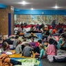 People sit and lie on the floor in the improvised bomb shelter in a sports center, which can accommodate up to 2000 people, in Mariupol, Ukraine, late Sunday, Feb. 27, 2022. Explosions and gunfire that have disrupted life since the invasion began last week appeared to subside around Kyiv overnight, as Ukrainian and Russian delegations prepared to meet Monday, Feb. 28, 2022 on Ukraine's border with Belarus. It's unclear what, if anything, those talks would yield. Terrified Ukrainian families huddled in shelters, basements or corridors, waiting to find out. (AP Photo/Evgeniy Maloletka)