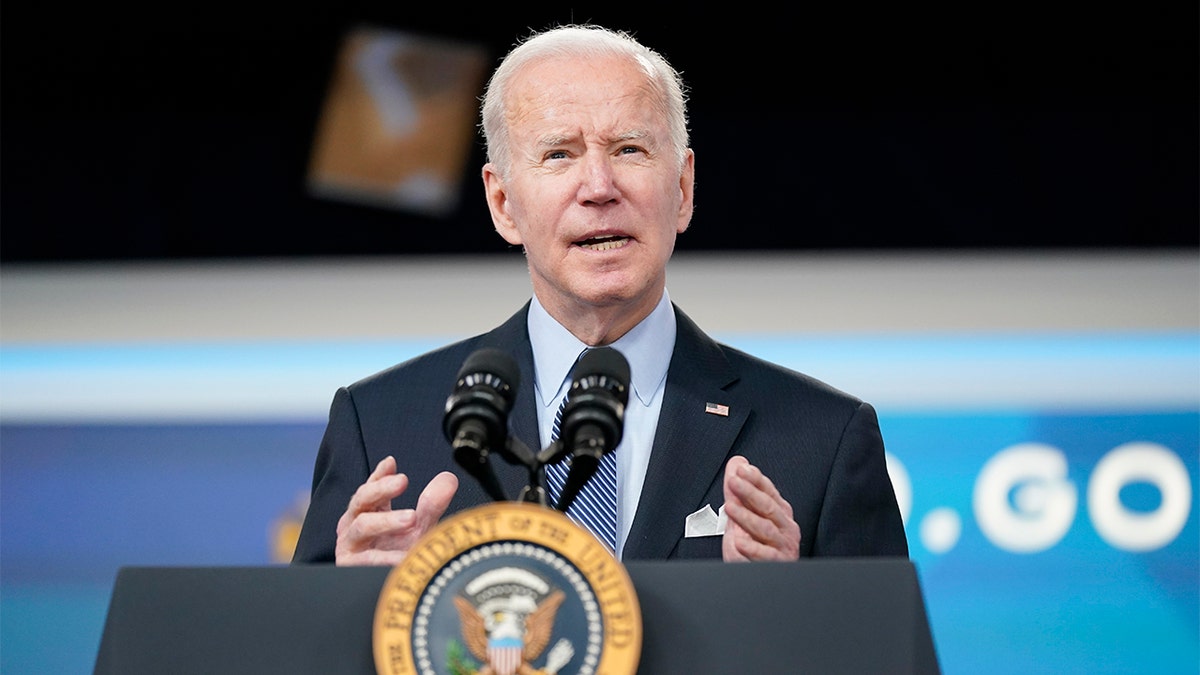 Joe Biden speaking from podium in a suit with a striped tie