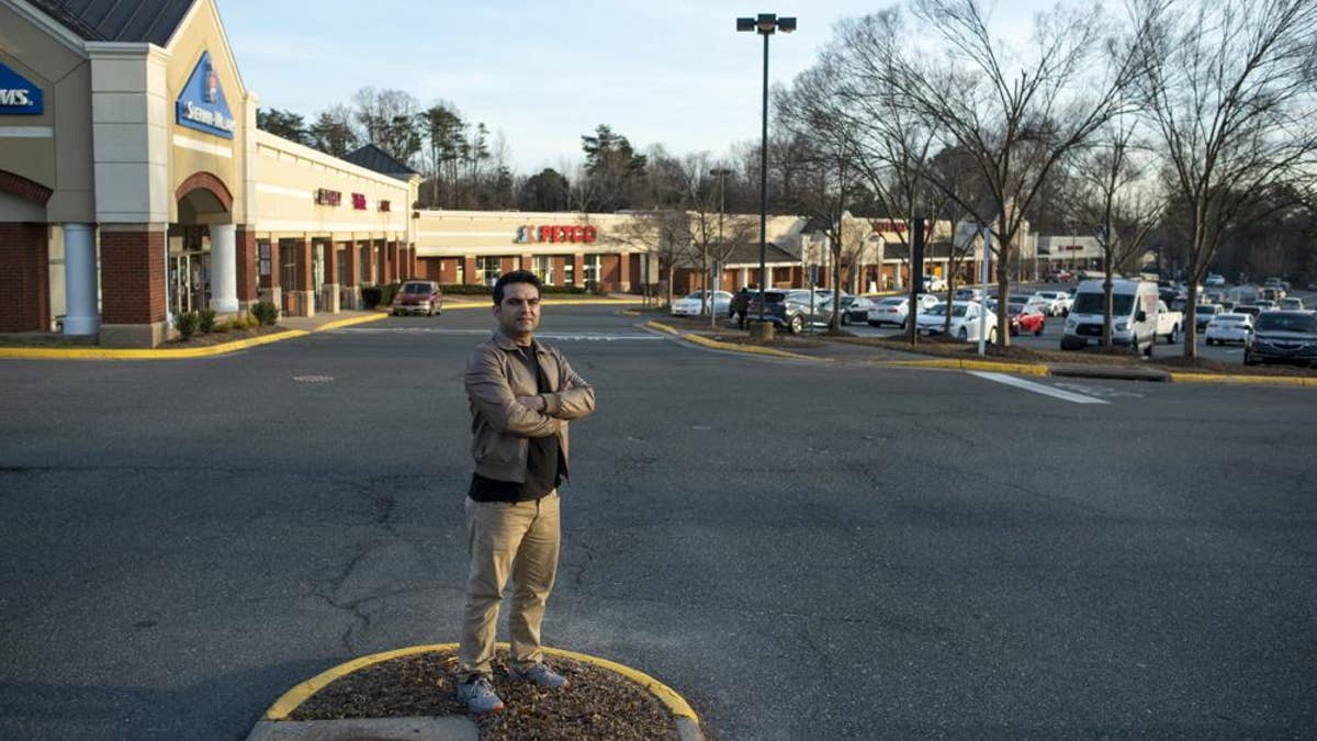 Afghan refugee Ahmad Saeed Totakhail poses for a photograph at a shopping center near his home in Dale City, Va., Wednesday, Feb. 16, 2022.