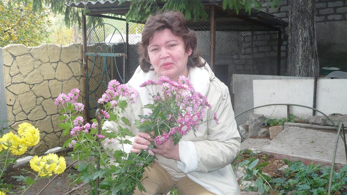 Matthew Frantsuzhan's grandmother, Galina, holds flowers in the garden of her home in Ukraine. He said his grandmothers will not leave their native land. "They have spent their lives there," he told Fox News Digital.