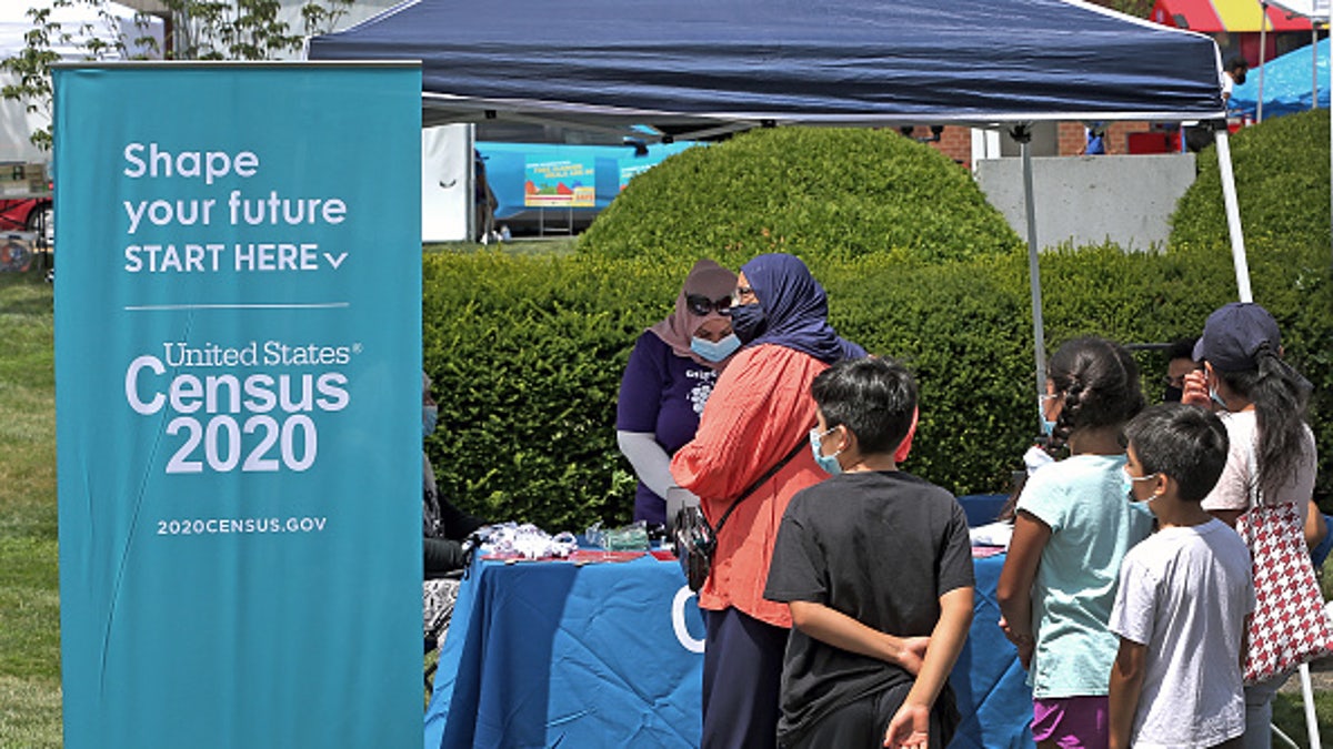 People stand in line at a Census 2020 booth at a farmer's market in Everett, MA on July 24, 2020. 