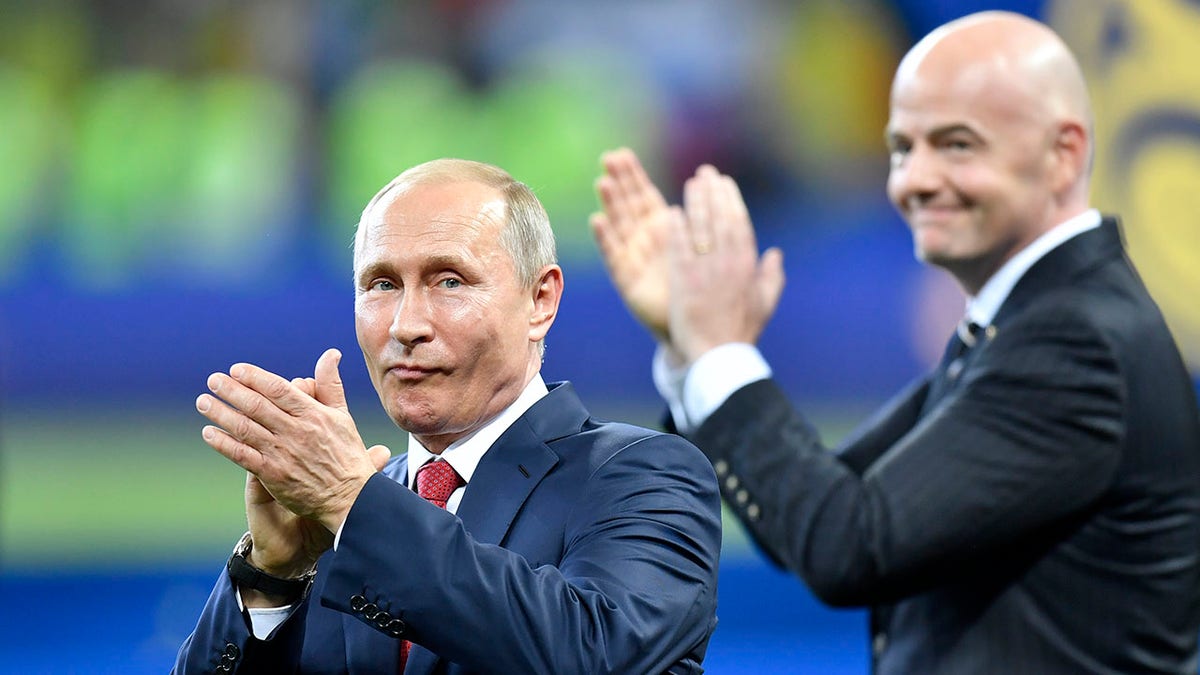 FILE - Russian President Vladimir Putin, left, applauds beside FIFA President Gianni Infantino at the end of the 2018 World Cup final soccer match between France and Croatia in the Luzhniki Stadium in Moscow, Russia, July 15, 2018. FIFA and UEFA have today decided together that all Russian teams, whether national representative teams or club teams, shall be suspended from participation in both FIFA and UEFA competitions until further notice.