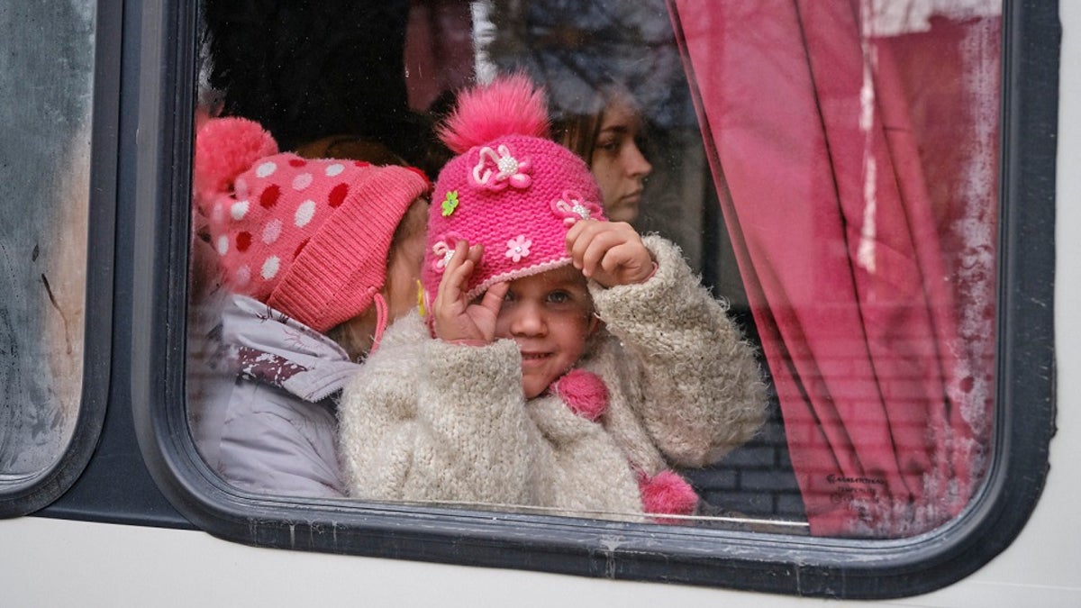 A Ukrainian girl sits in a vehicle with other children arranged by Aerial Recovery.
