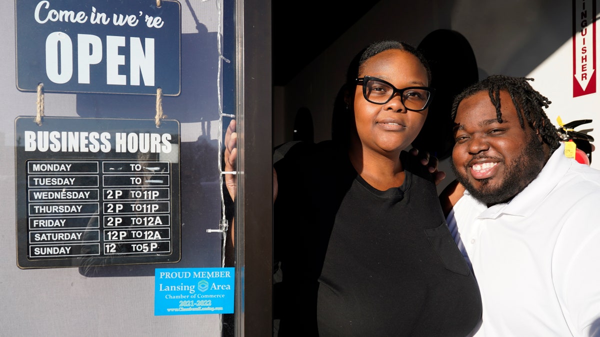 Deja Cousins-Cain, left, and her husband Christopher Cain pose for a photo at their S.L. Wine Bar in Lansing, Ill.