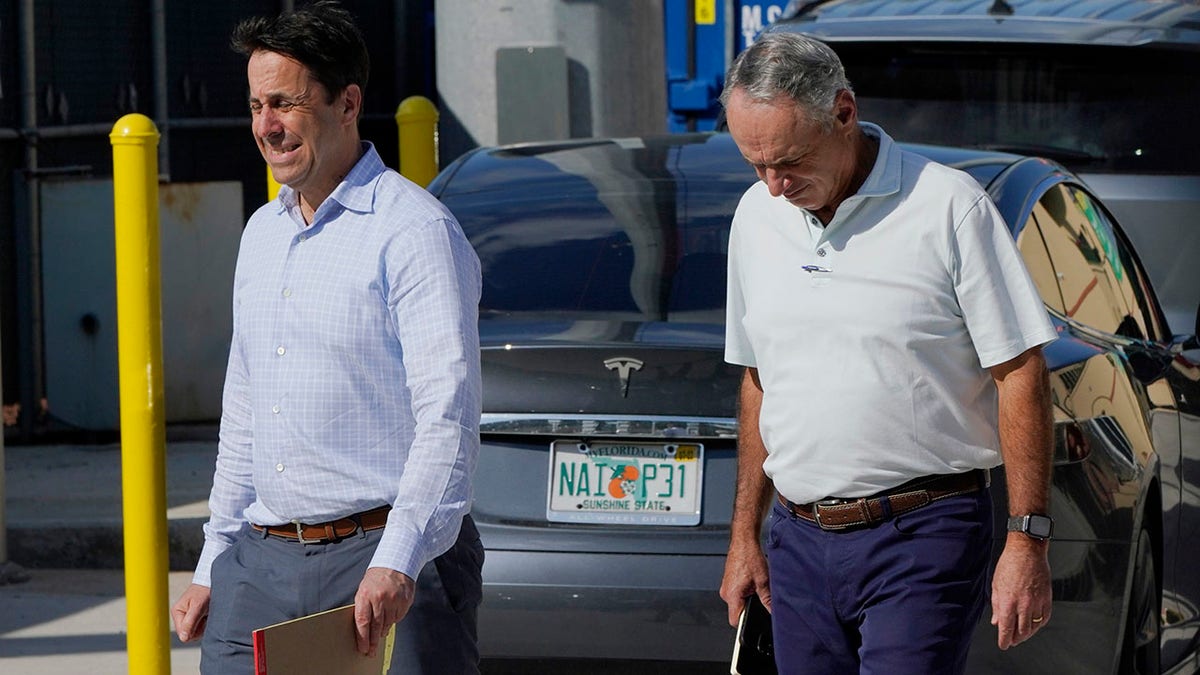 Major League Baseball Deputy Commissioner Dan Halem, left, and Commissioner Rob Manfred, right, walk after negotiations with the players association in an attempt to reach an agreement to salvage March 31 openers and a 162-game season, Monday, Feb. 28, 2022, at Roger Dean Stadium in Jupiter, Fla.