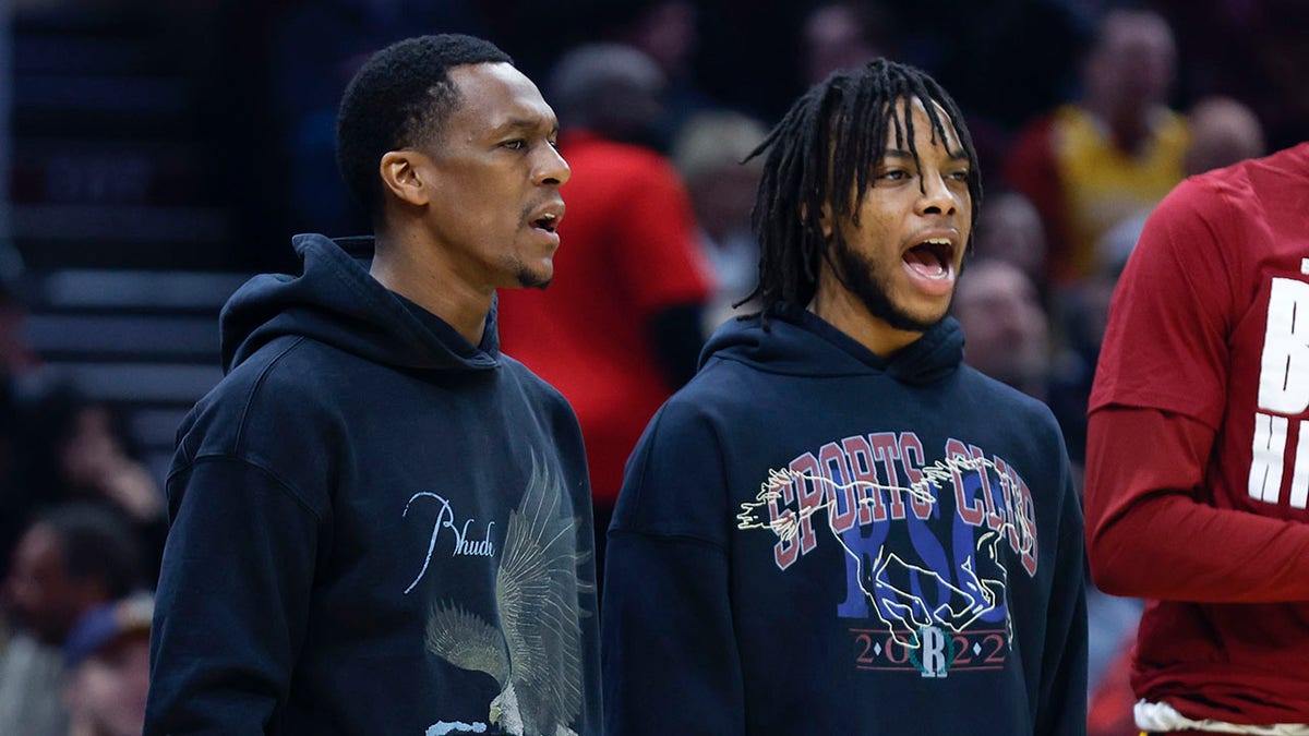 Injured Cleveland Cavaliers guards Rajon Rondo, left, and Darius Garland cheer for teammates during the first half of the team's NBA basketball game against the Minnesota Timberwolves, Monday, Feb. 28, 2022, in Cleveland.