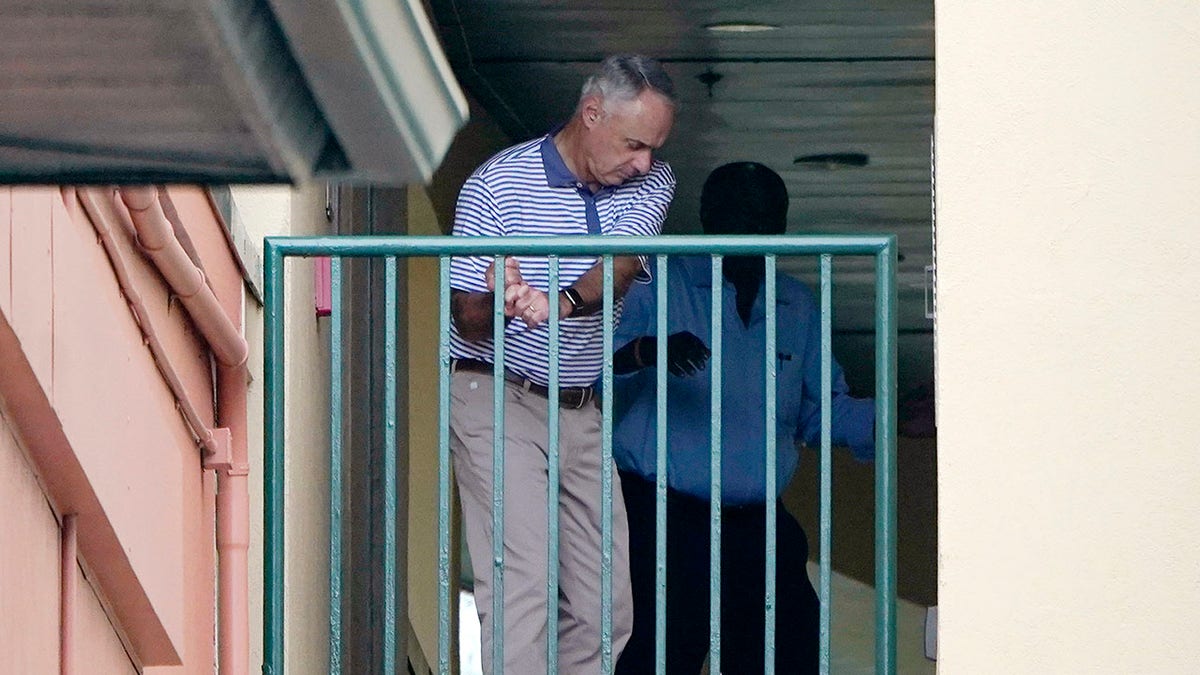Major League Baseball Commissioner Rob Manfred practices his golf swing as negotiations continue with the players' association toward a labor deal, Tuesday, March 1, 2022, at Roger Dean Stadium in Jupiter, Fla.