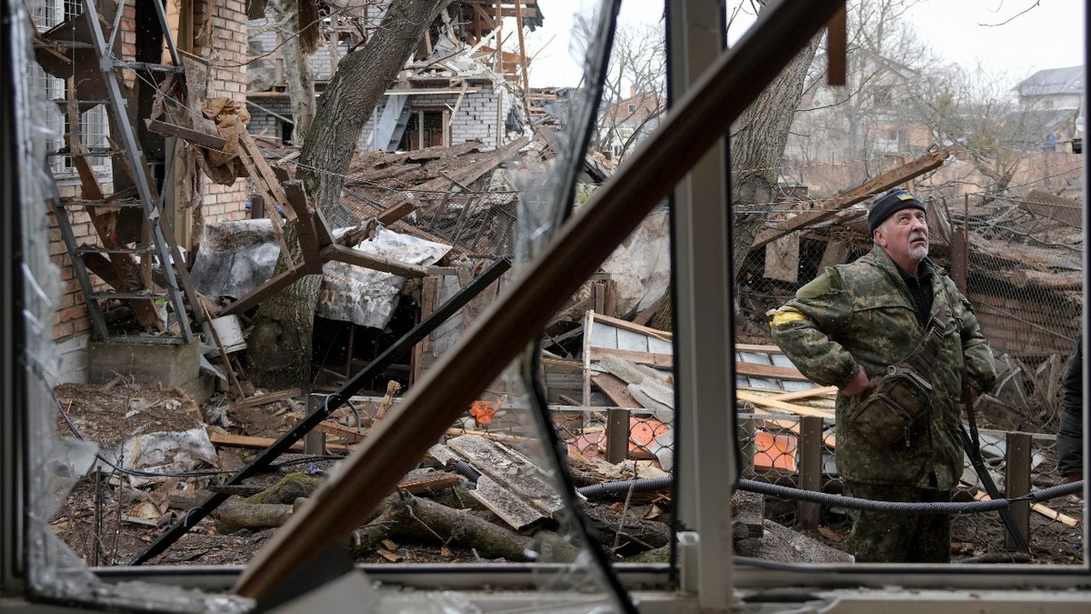 Andrey Goncharuk, 68, a member of the territorial defense stands in the backyard of a house damaged by a Russian airstrike, according to locals, in Gorenka, outside the capital Kyiv, Ukraine, Wednesday, March 2, 2022. Russia renewed its assault on Ukraine's second-largest city in a pounding that lit up the skyline with balls of fire over populated areas, even as both sides said they were ready to resume talks aimed at stopping the new devastating war in Europe. (AP Photo/Vadim Ghirda)