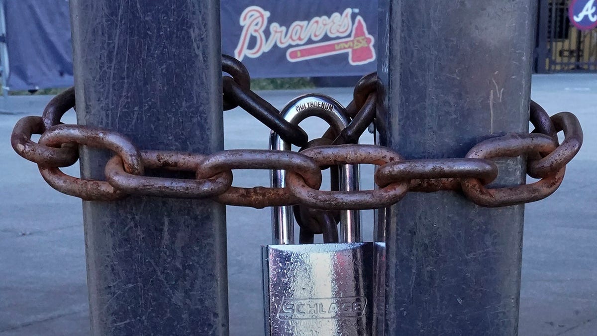 Locked gates are shown at Truist Park, home of the Atlanta Braves baseball team, Wednesday, March 2, 2022, in Atlanta. With owners and players unable to agree on a labor contract to replace the collective bargaining agreement that expired Dec. 1, baseball commissioner Rob Manfred followed through with his threat on Tuesday and canceled the first two series for each of the 30 major league teams.