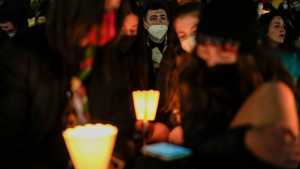 People hold candles as they take part in a prayer vigil to protest against the Russian invasion of Ukraine, in St.Peter's Square, at the Vatican, Wednesday, March 2, 2022. 