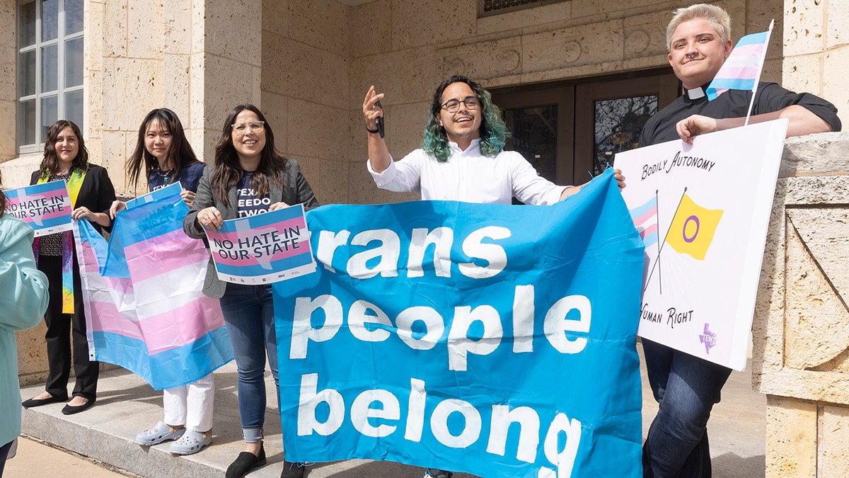 Adri Perez, ACLU of Texas Policy and Advocacy Strategist, center, and other LGBTQ leaders speak outside the Travis County courthouse where a hearing was held to stop the new child welfare investigations targeting supportive families of transgender children, on Wednesday, Mar. 02, 2022, in Austin.