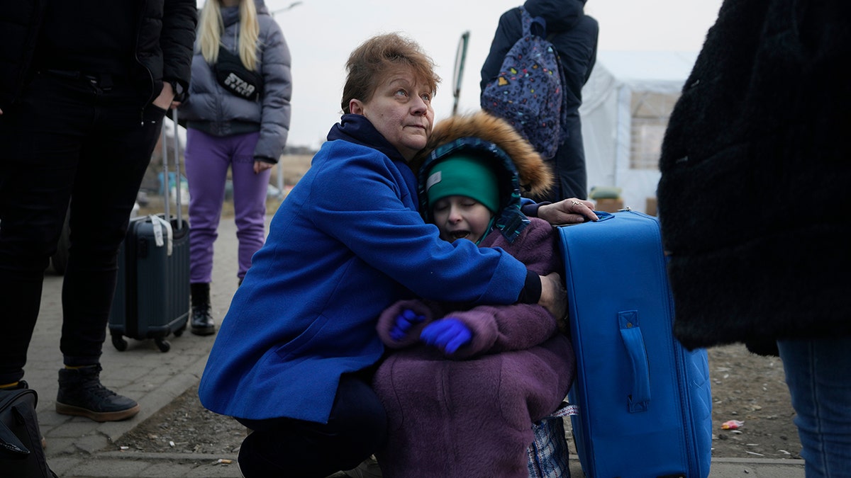 A woman holds a small girl at a border crossing as refugees flee a Russian invasion in Medyka, Poland, Thursday, March 3, 2022.
