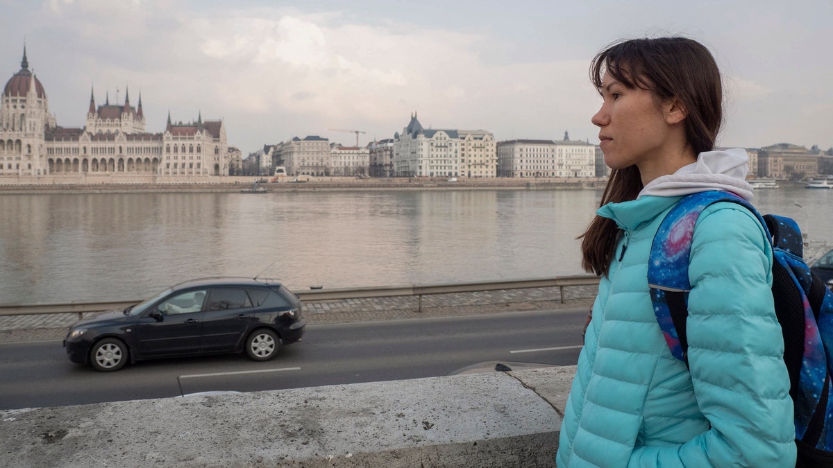 Olena, a Russian citizen fleeing from Kyiv, Ukraine (no family name given for safety reason) looks at the Hungarian Parliament building and the River Danube in downtown Budapest on Friday, March 4, 2022.