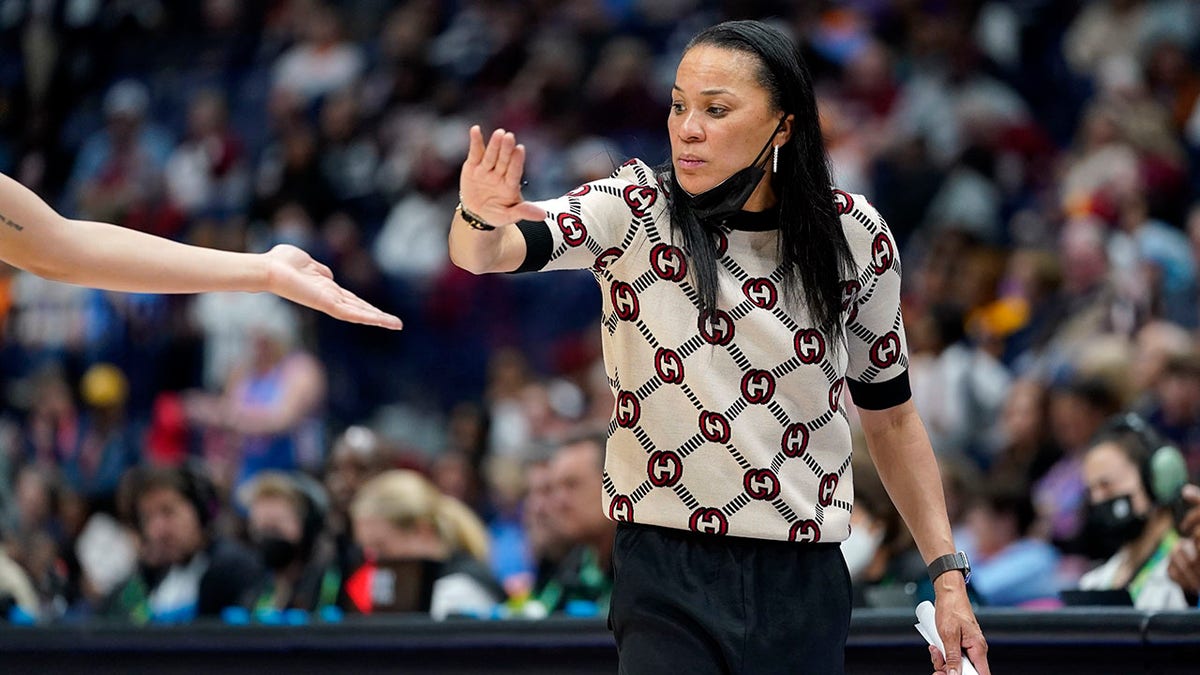 South Carolina head coach Dawn Staley congratulates a player during the second half of an NCAA college basketball semifinal round game against Mississippi at the women's Southeastern Conference tournament Saturday, March 5, 2022, in Nashville, Tenn. South Carolina won 61-51.