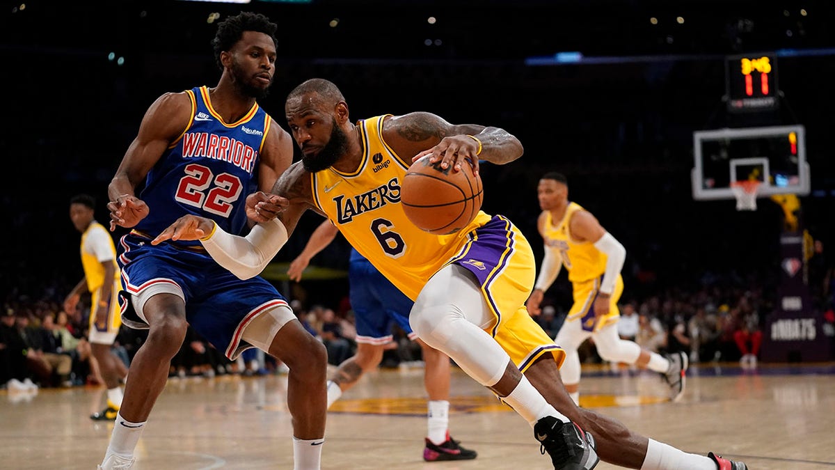 Los Angeles Lakers forward LeBron James (6) drives against Golden State Warriors forward Andrew Wiggins (22) during the first half of an NBA basketball game in Los Angeles, Saturday, March 5, 2022.